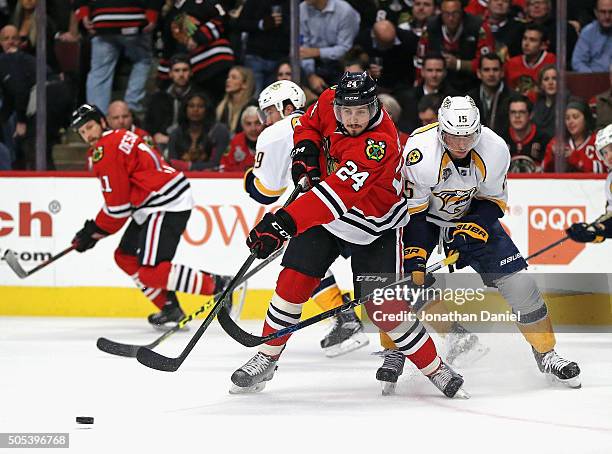 Phillip Danault of the Chicago Blackhawks passes under pressure from Craig Smith of the Nashville Predators at the United Center on January 12, 2016...