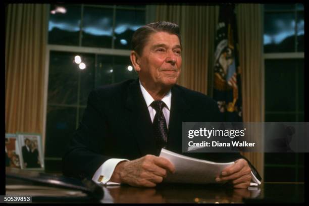 President Ronald Reagan sitting at desk in the Oval Office of the White House after adressing the nation, re Iran-Contra affair.