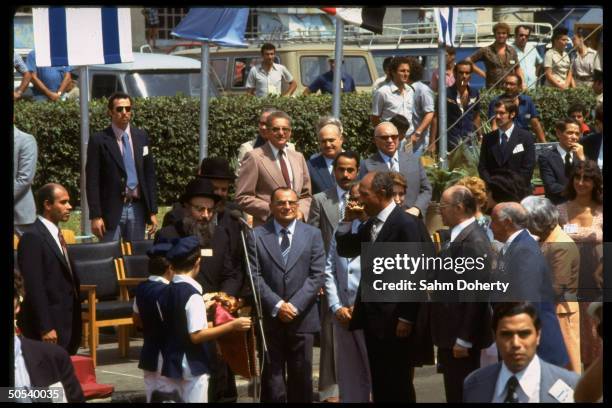 Israeli Prime Minister Menachem Begin watching Egyptian President Anwar eat ceremonial bread and salt as Joseph Burg, Kamal Hassan Ali and Ezer...