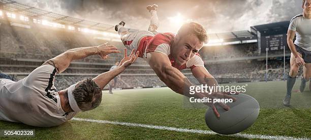 rugby player scoring and being tackled in mid air dive - rugby sport stock pictures, royalty-free photos & images