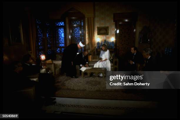 Jordan's King Hussein sitting with bride Lisa Halaby during their wedding ceremony at the royal palace.