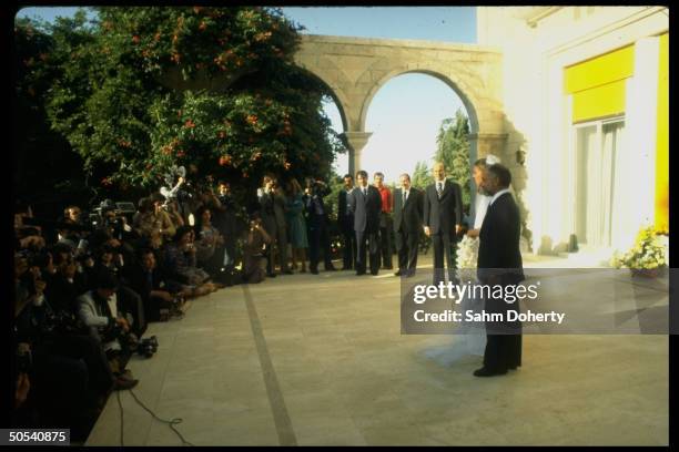 Jordan's King Hussein and new bride Lisa Halaby standing before the press after their wedding ceremony at the royal palace.