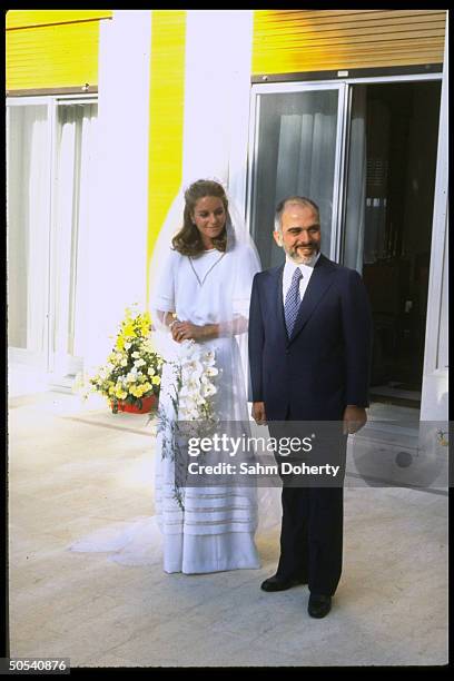 Jordan's King Hussein standing with new bride Lisa Halaby at the royal palace.