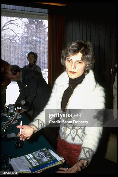 West German Greens Party leader Petra Kelly standing behind table with copies of her book during press conference.