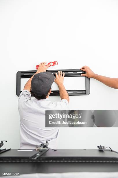 series-real televison installers hanging bracket for large flat screen tv - bracket stock pictures, royalty-free photos & images
