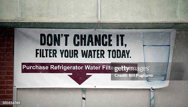 Sign on a the front of a building warns residents to filter their water January 17, 2016 in Flint, Michigan. U.S. President Barack Obama declared a...