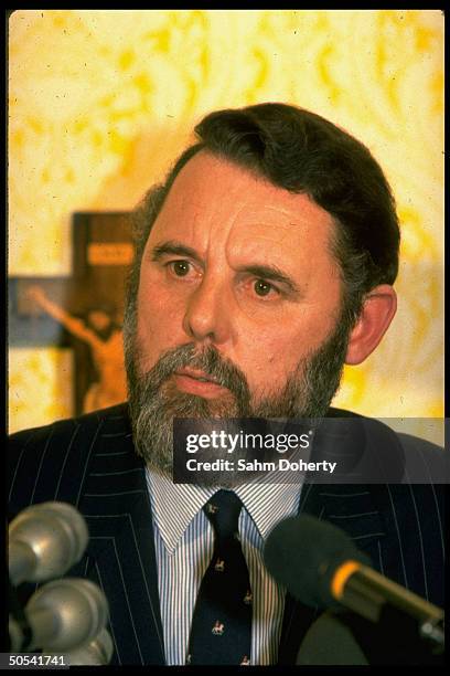 Hostage negotiator/Anglican church envoy Terry Waite sitting in front of microphones at press conference.