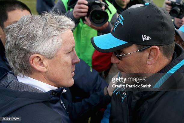 Head coach Ron Rivera of the Carolina Panthers speaks with head coach Pete Carroll of the Seattle Seahawks after the NFC Divisional Playoff Game at...