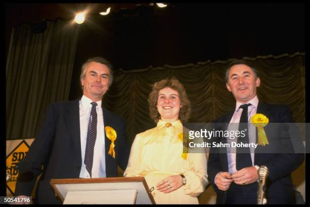 Liberal Party leaders David Steel and David Owen standing beside SPD/Liberal Party candidate Rosie Barnes at a rally for her election.
