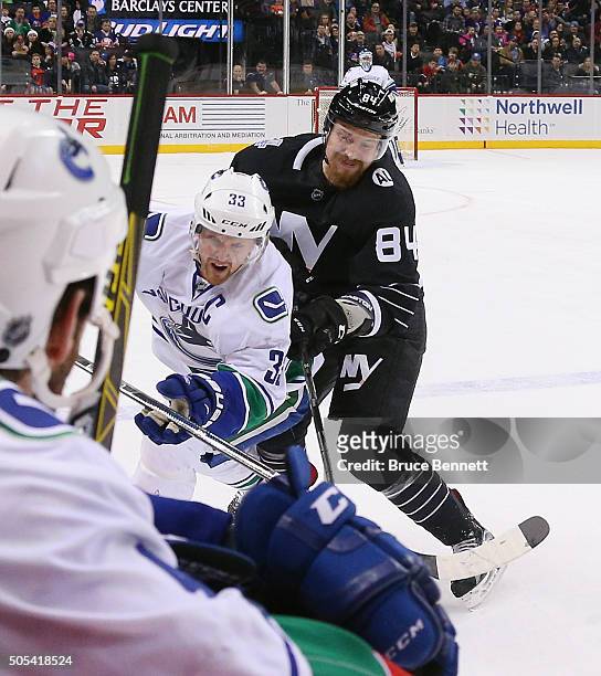 Mikhail Grabovski of the New York Islanders takes a major penalty for boarding against Henrik Sedin of the Vancouver Canucks during the first period...