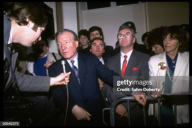 Fianna Fail Prime Minister candidate Charles Haughey speaking into microphone while standing with supporters during election vote count.