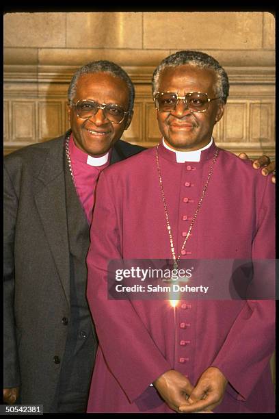 Archbishop Desmond Tutu standing beside life-like wax dummy of himself at Madame Tussaud's wax museum.
