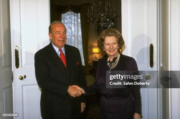 British Prime Minister Margaret Thatcher shaking hands with US Secretary of State George Shultz at 10 Downing Street.