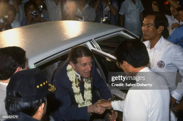 Secretary of Defense Caspar Weinberger shaking hands with Philippine Defense Minister Juan Ponce Enrile while stepping out of his car upon arrival in...