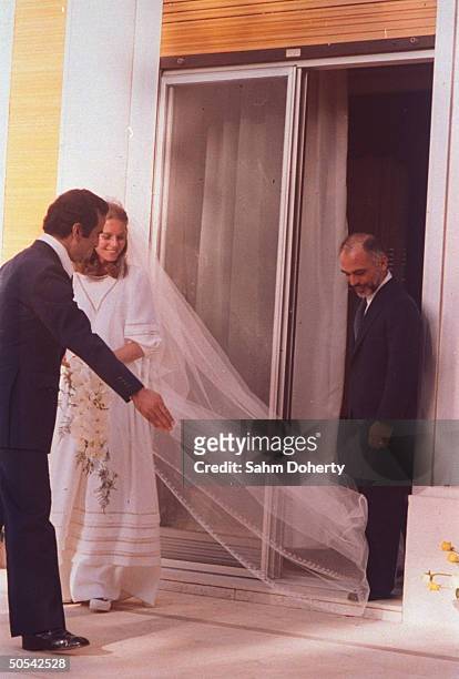 Jordan's King Hussein standing with new bride Lisa Halaby at the royal palace.