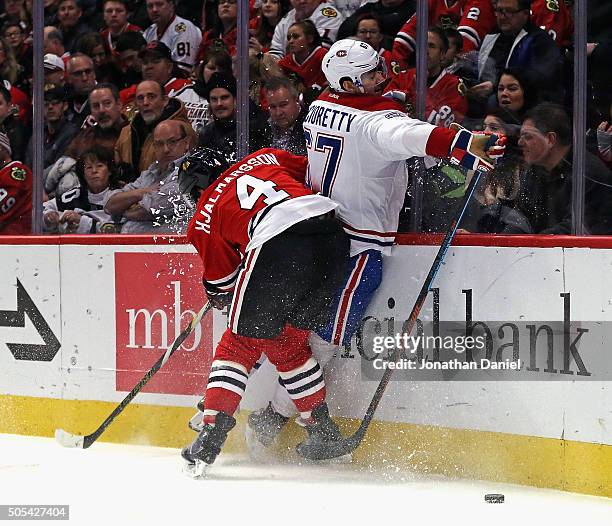 Niklas Hjalmarsson of the Chicago Blackhawks checks Max Pacioretty of the Montreal Canadiens into the boards at the United Center on January 17, 2016...