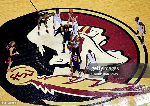 Boris Bojanovsky of the Florida State Seminoles and Anthony Gill of the Virginia Cavaliers tip off to start the game at Donald L. Tucker Center on...