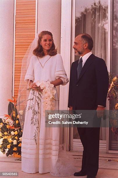 Jordan's King Hussein standing with new bride Lisa Halaby at the royal palace.