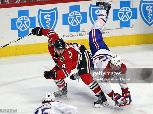 Jeff Petry of the Montreal Canadiens falls over the back of Niklas Hjalmarsson of the Chicago Blackhawks at the United Center on January 17, 2016 in...