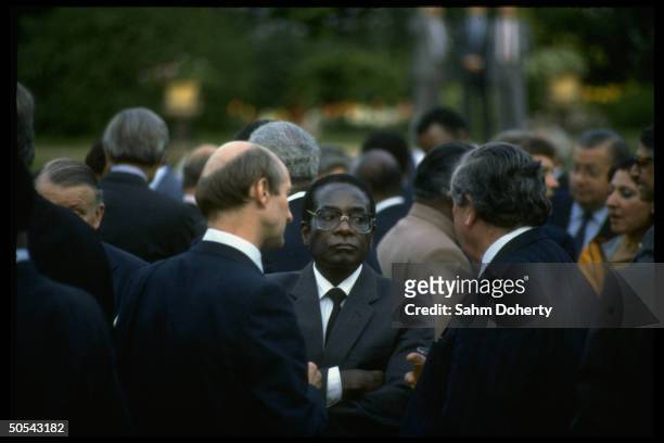 Zimbabwe ldr. Robert Mugabe chatting w. Unidents. Outside Commonwelath meeting