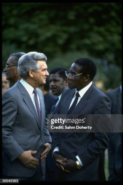 Australian PM Robert Hawke chatting w. Zimbabwe ldr. Robert Mugabe outside Commonwealth meeting