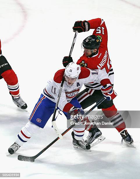 Artem Anisimov of the Chicago Blackhawks tries to knock the puck away from Brendan Gallagher of the Montreal Canadiens at the United Center on...