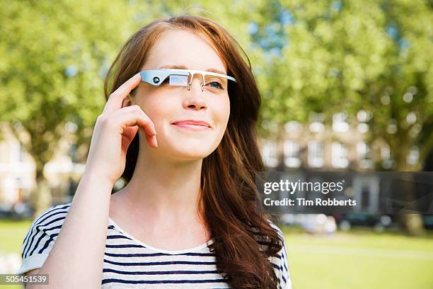 young woman using smart-glass in urban park. - datenbrille stock-fotos und bilder