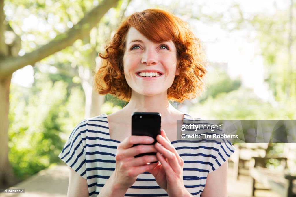 Woman using smart phone outside.