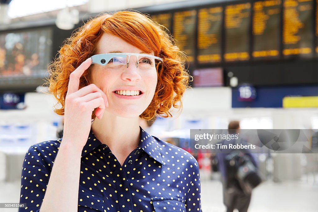 Woman using Smart-Glass at train station.