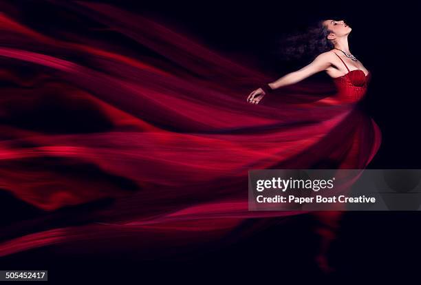 woman in a long red flowing dress - red dress photos et images de collection