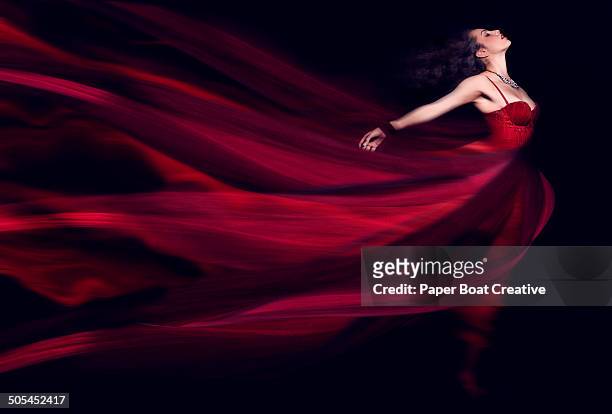 woman in a long red flowing dress - red dress ストックフォトと画像