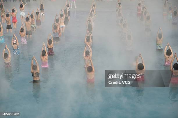 Yoga fans practice in a hot spring on January 17, 2016 in Luoyang, Henan Province of China. Nearly a hundred yoga fans performed yoga in a hot spring...