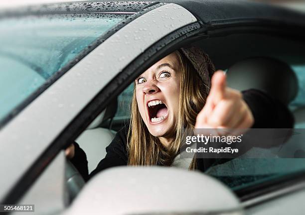 road rage! enraged young woman driver shouts and points accusingly. - road rage stock pictures, royalty-free photos & images