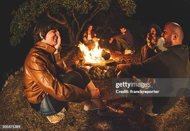 campfire of friends in circle on the fire - campfire storytelling stock pictures, royalty-free photos & images