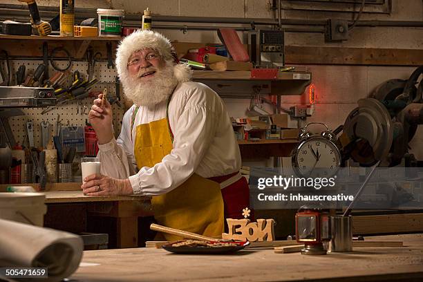 santa claus taking a break from working in his workshop - santa leaning stock pictures, royalty-free photos & images