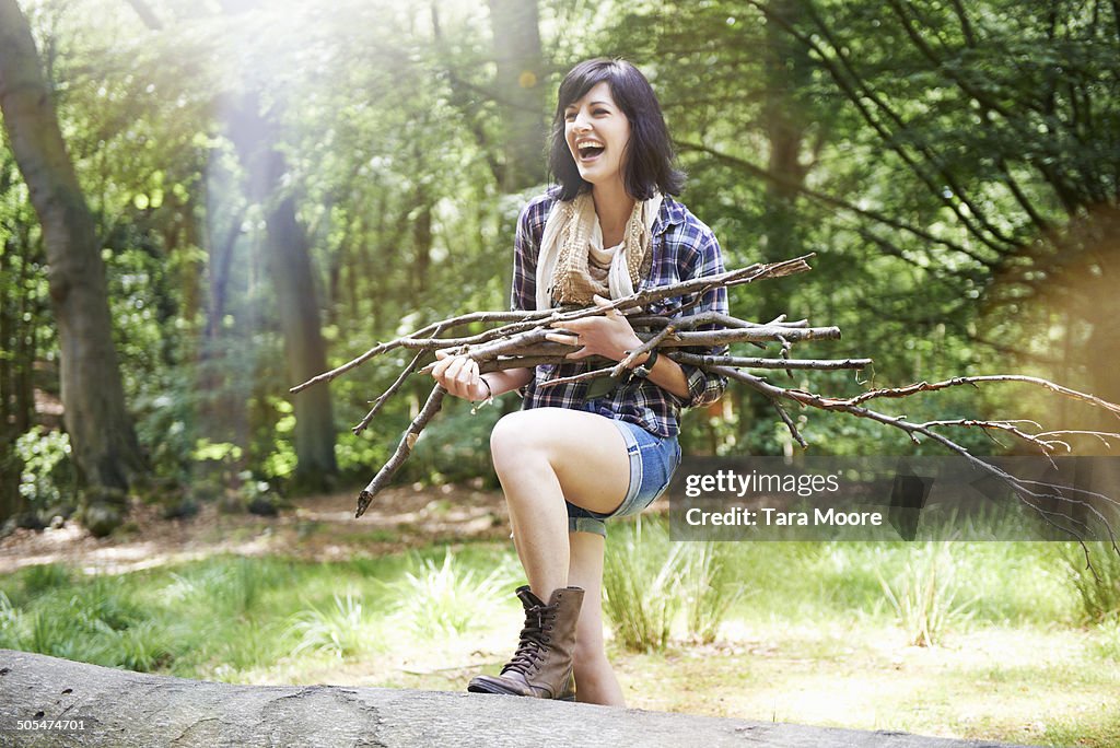 Woman collecting firewood in forest