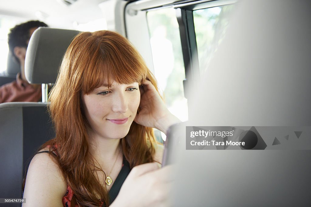 Woman texting on phone in car