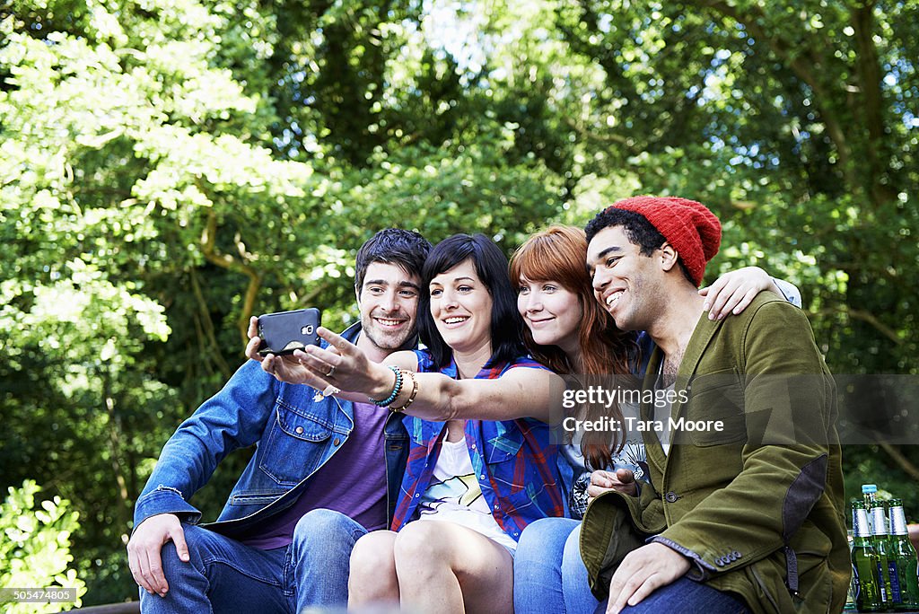 Four friends taking selfie in park