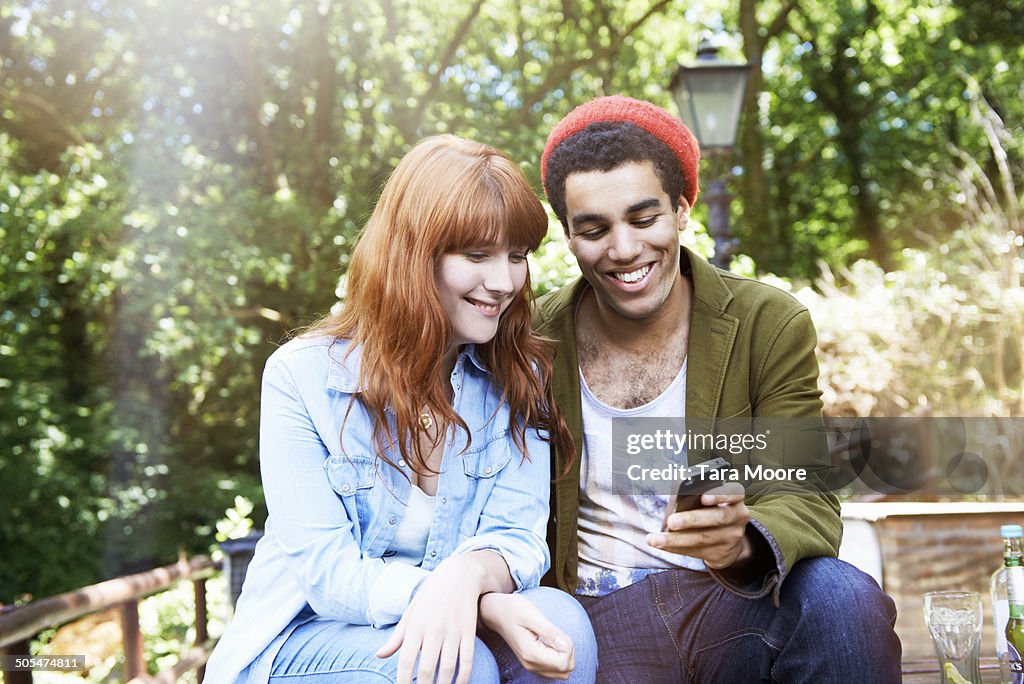 Man and woman looking at mobile in park