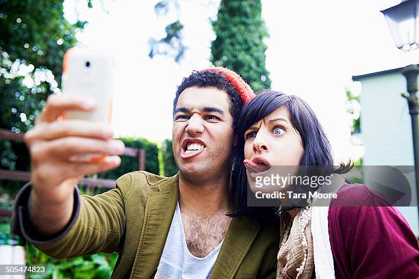 man and woman making funny faces for selfie - pull a face stock pictures, royalty-free photos & images