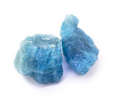 Blue aquamarine raw gemstones on the white background.