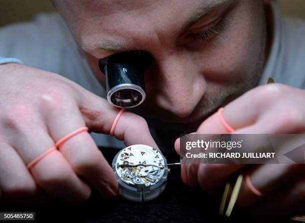 An employee of German watchmaker A. Lange & Soehne assembles a wristwatch, during the opening day of the "Salon International de la Haute Horlogerie"...