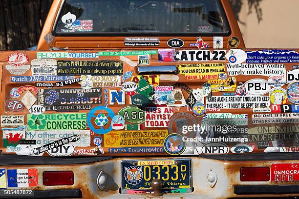 bumper stickers galore: back of veteran's rusty pickup truck - bumper sticker stock pictures, royalty-free photos & images