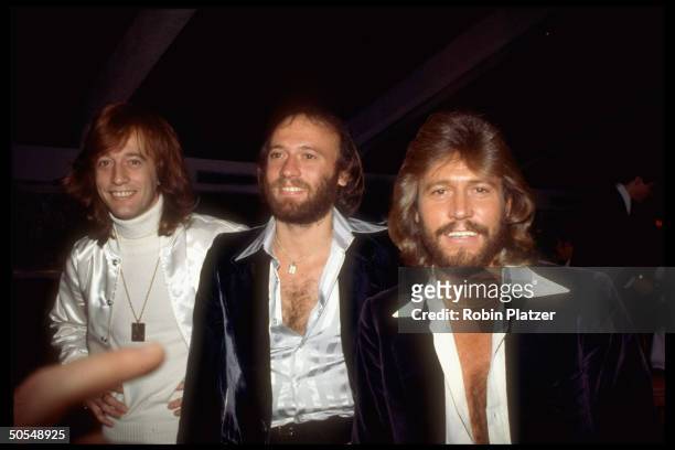 Members of the Bee Gees, Barry, Maurice, and Robin.