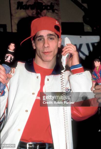 Member from the rock group New Kids on the Block holding up NKOTB merchandise.
