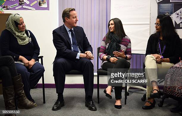 British Prime Minister David Cameron , speaks with women attending an English language class during a visit to the Shantona Women's Centre in Leeds,...