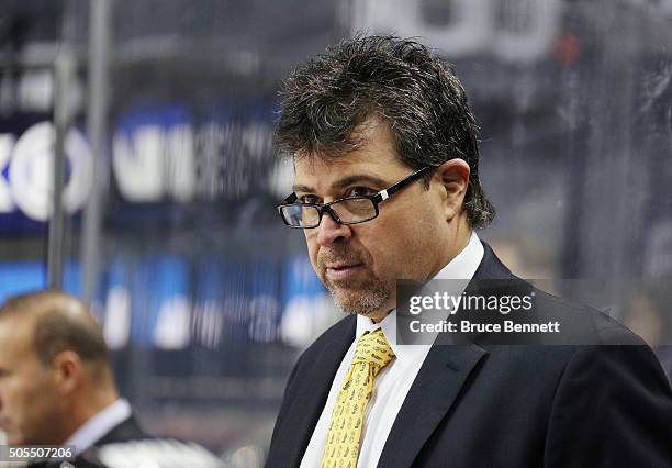 Cal Clutterbuck coach Jack Capuano of the New York Islanders watches the action from the bench against the Vancouver Canucks at the Barclays Center...