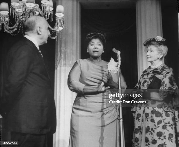 Singer Mahalia Jackson speaking at reception in hotel with composer Dimitri Tiomkin and Hedda Hopper .