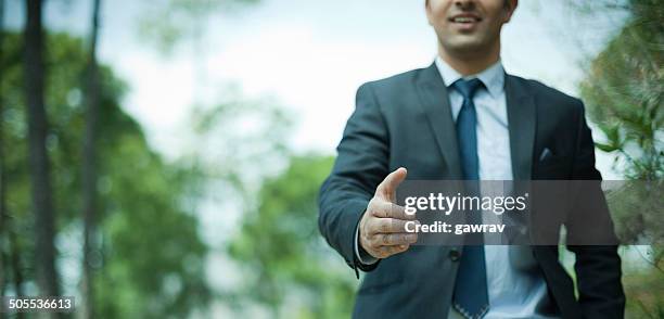 happy businessman offering for handshake in nature. - fresh deals stockfoto's en -beelden