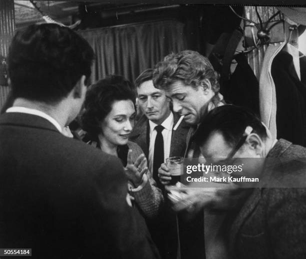 Actors John Neville and Peter O'Toole with his wife drinking at pub.